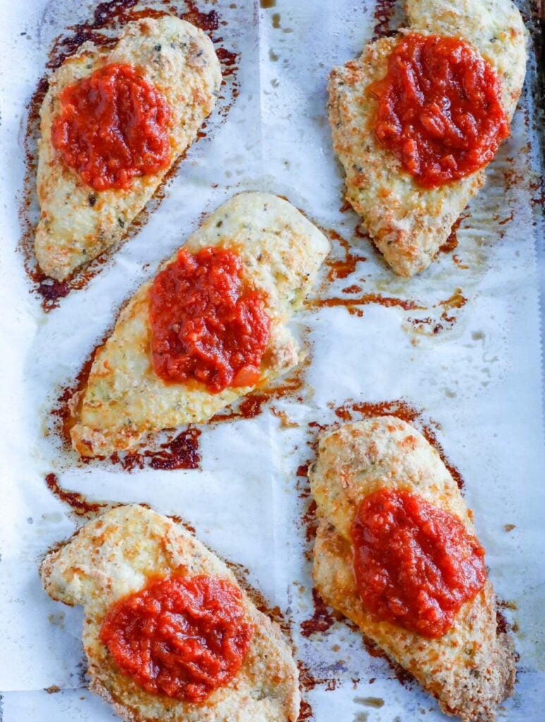 top down shot of baked chicken parm on tray 