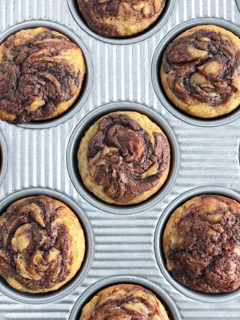 Nutella Swirl Banana Muffins in a muffin pan.