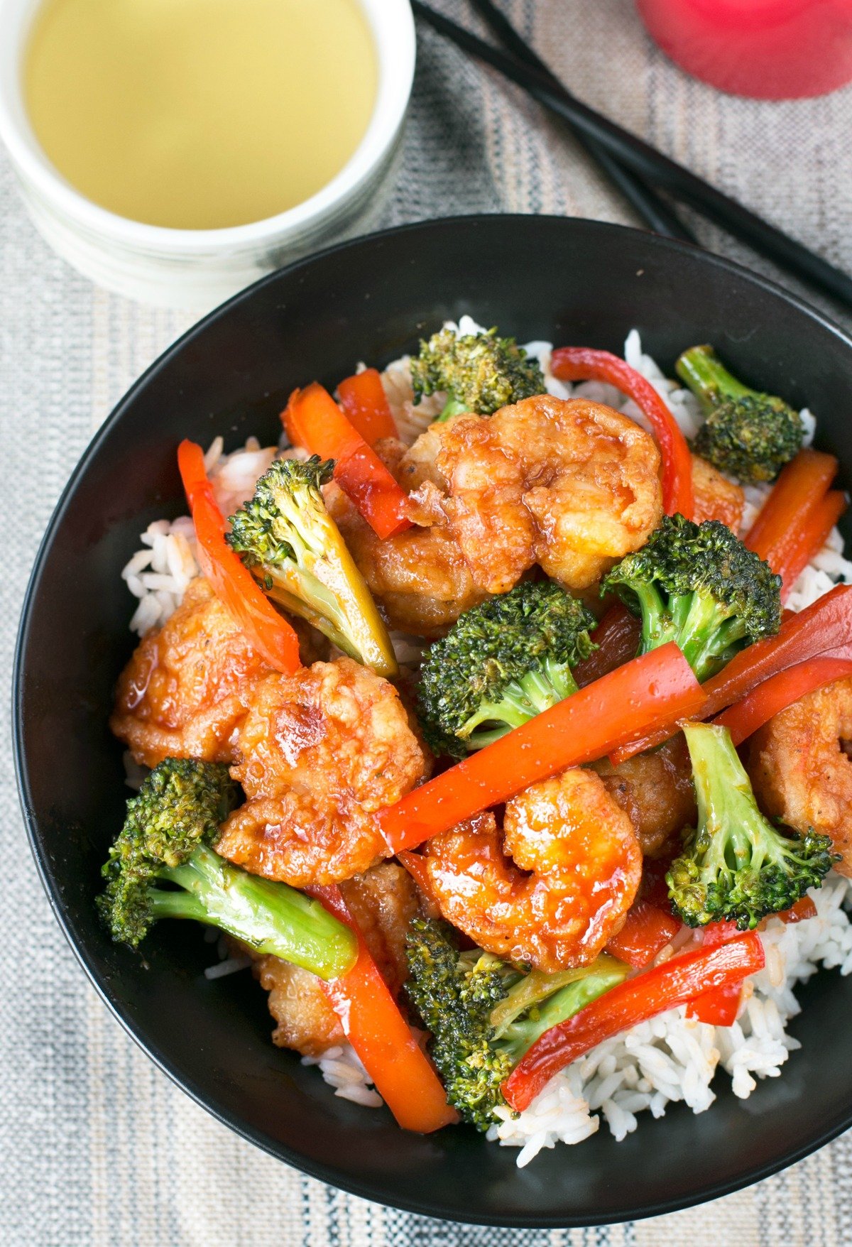 Overhead picture of a large black bowl filled with honey sriracha shrimp stir fry and rice