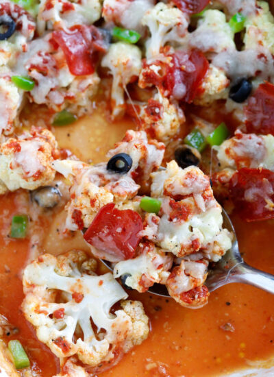 spoon taking out a scoop of Pizza Casserole from a baking dish