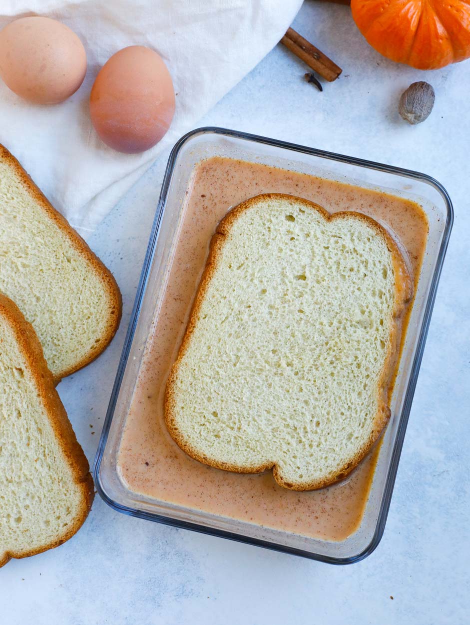 pumpkin spice french toast dredged in a glass bowl with 