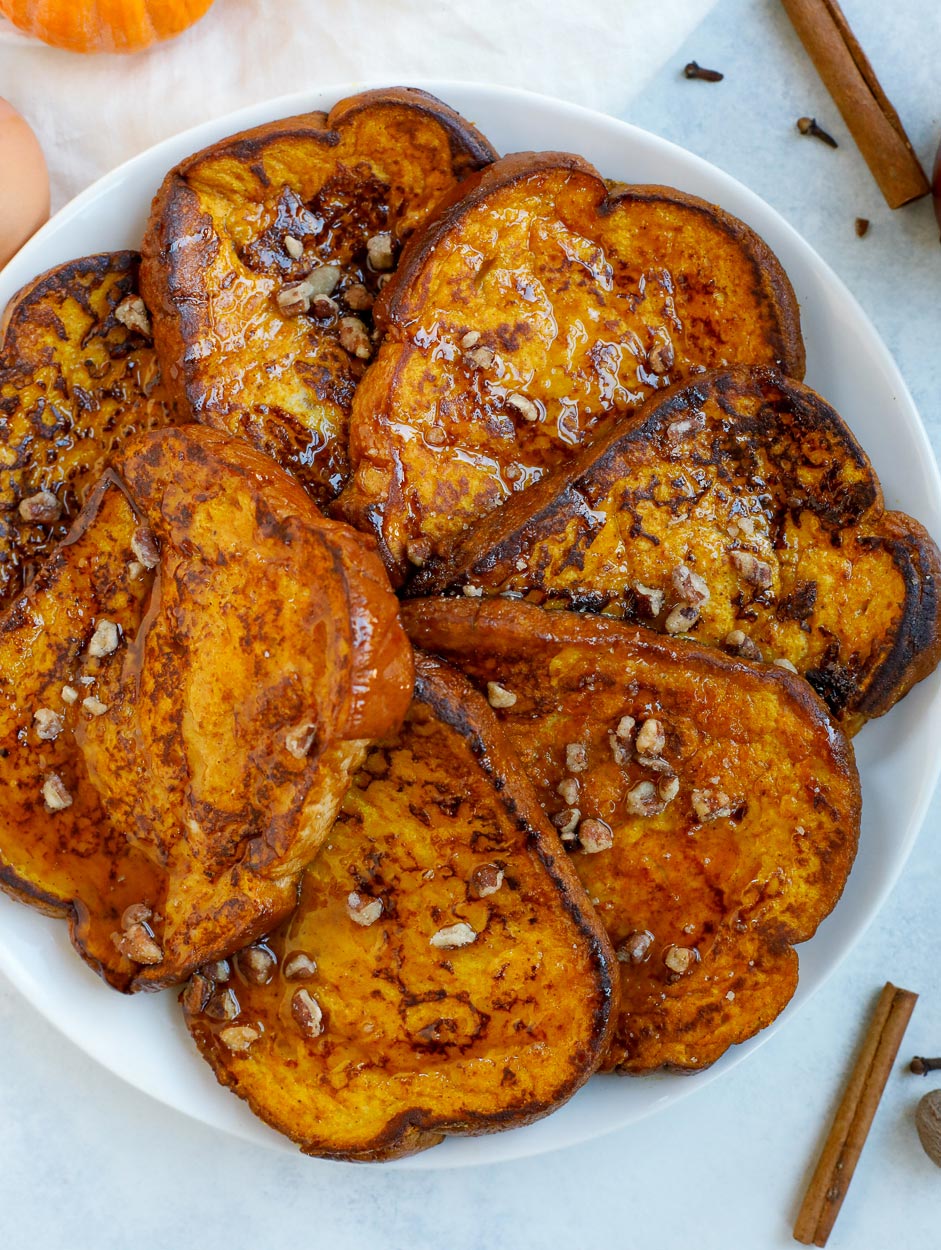 pumpkin french toast topped with maple syrup and crushed pecans