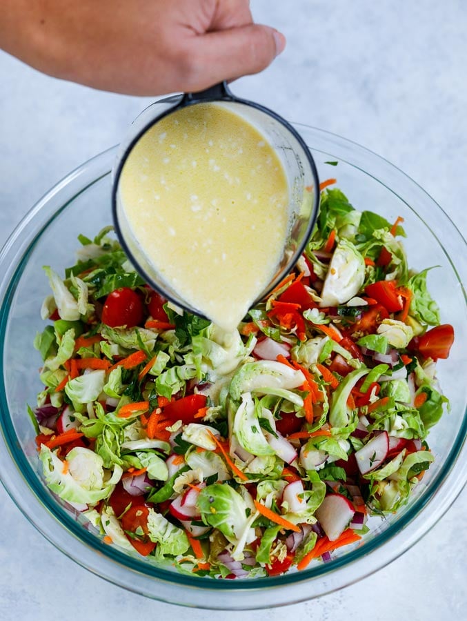 pouring salad dressing on veggies