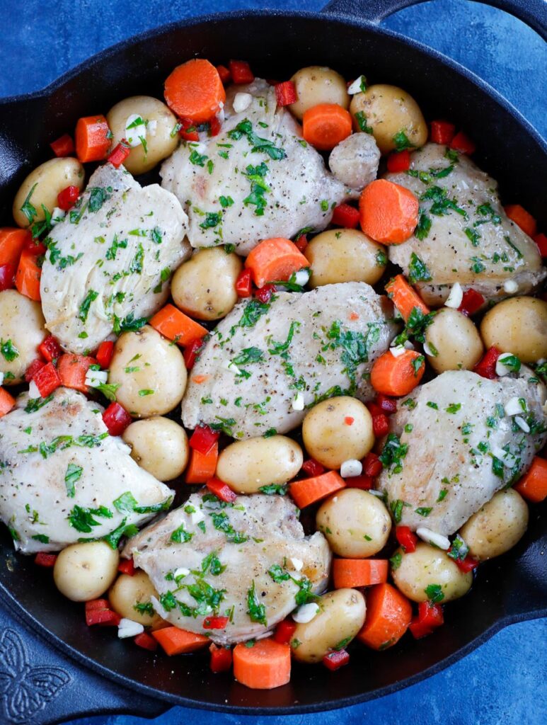 oven baked chickena nd potatoes top down shot of Chicken and potatoes in a skillet