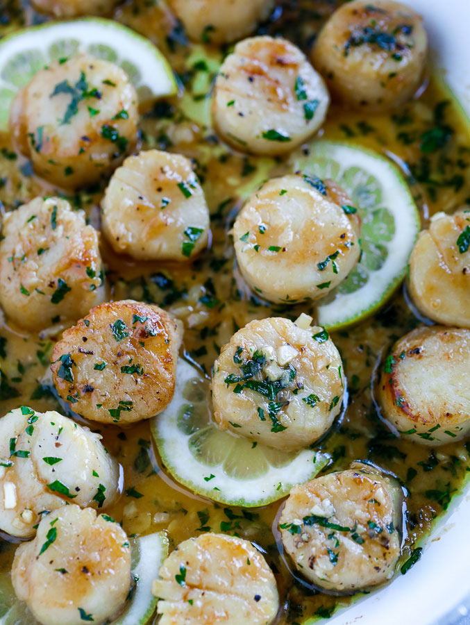 garlic scallops in a pan with lemon slices