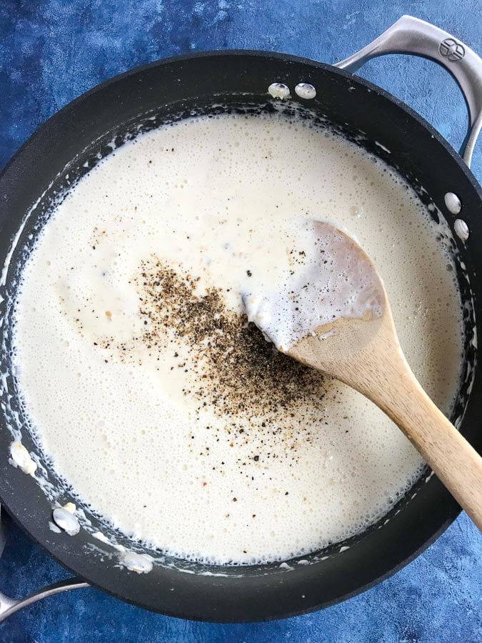 stirring creamy alfredo sauce