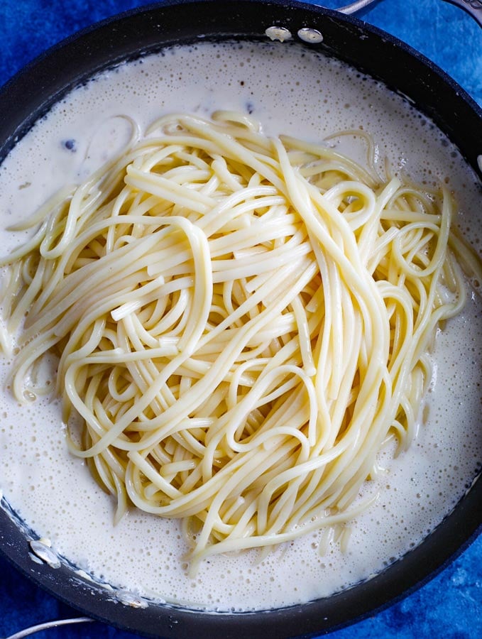 alfredo pasta cooking in a skillet