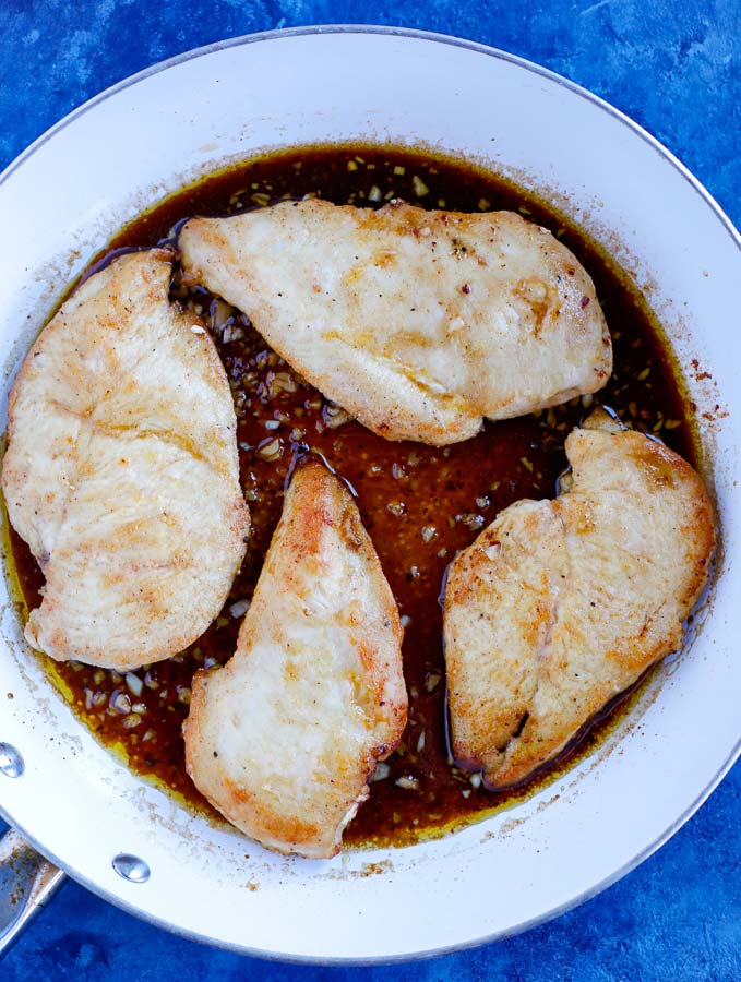 sticky chicken sauce over the chicken in a skillet