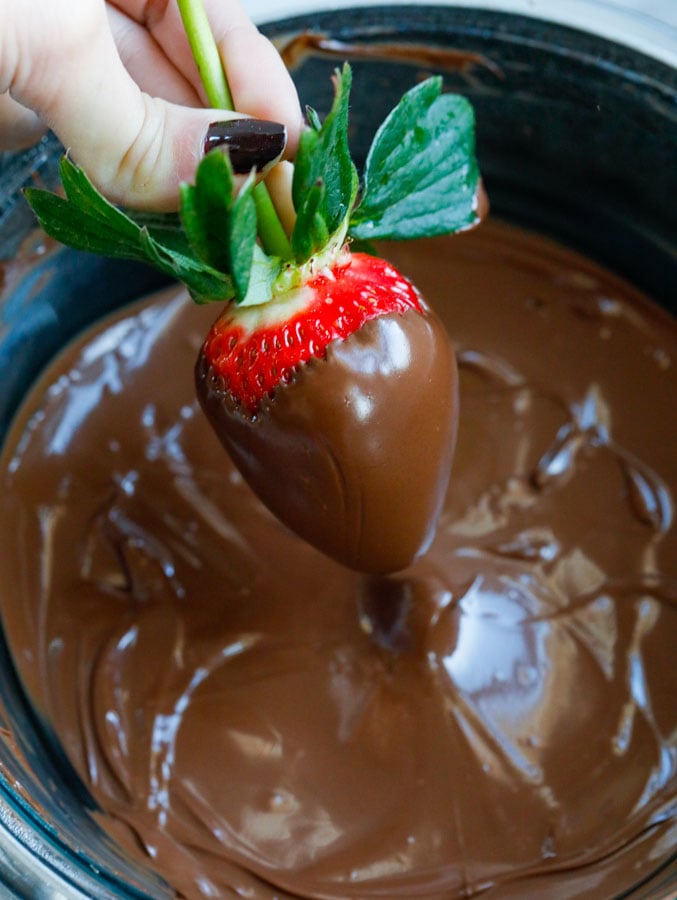 Dipping the strawberries into the chocolate.
