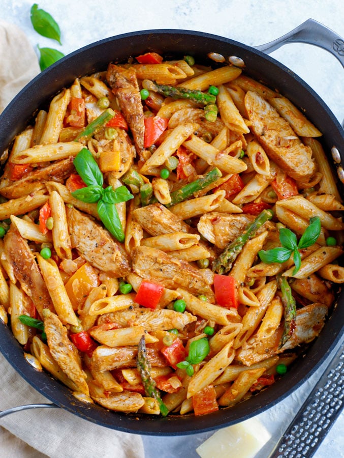 Skillet of Spicy Chicken Chipotle Pasta with parmesan cheese below the skillet.