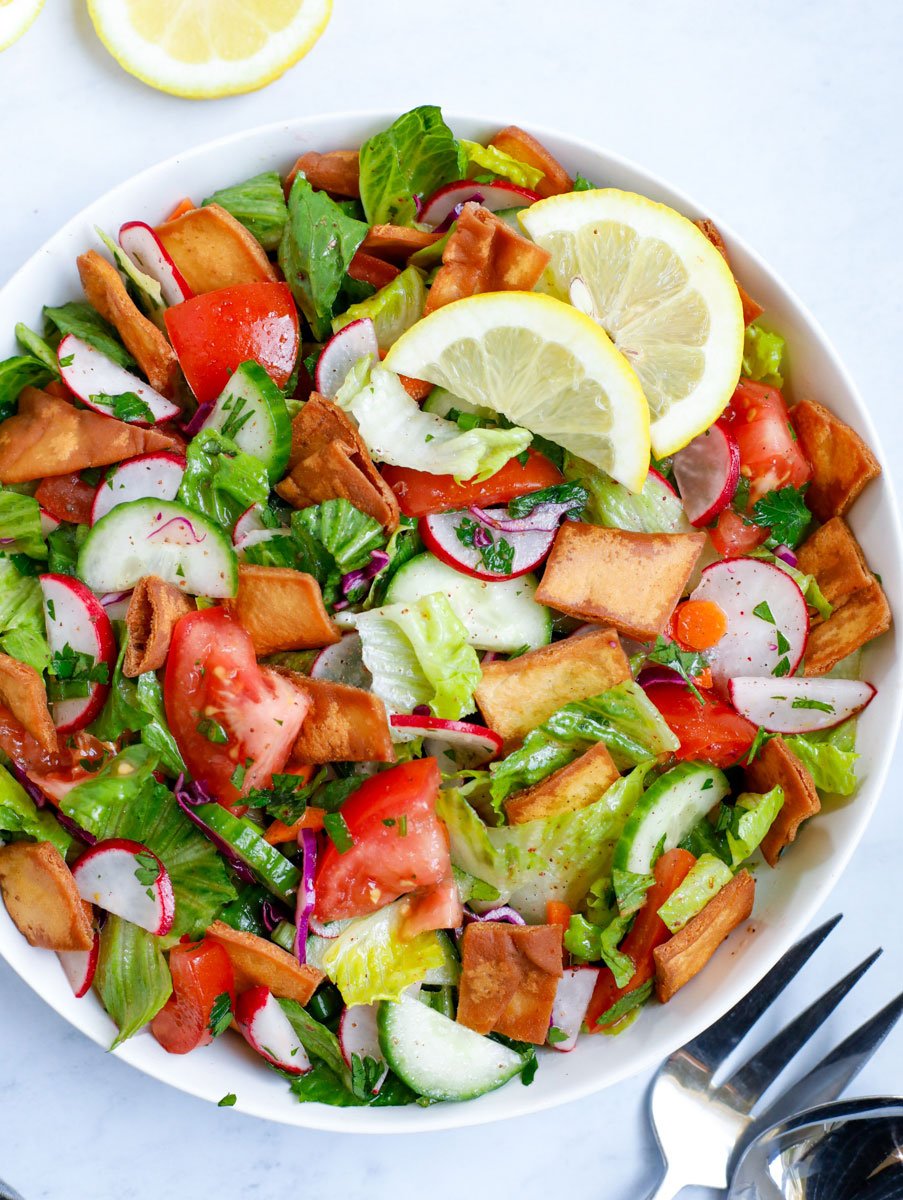 Lebanese Fattoush salad served in a white bowl with lemon slices