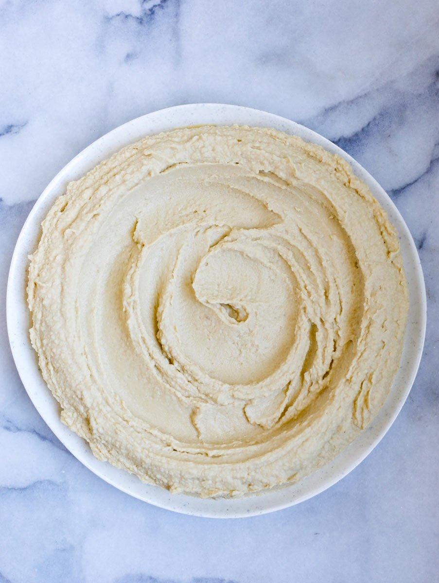 The Lebanese hummus in a white bowl after being blended
