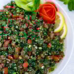 Lebanese tabbouleh garnished with sliced lemons and vegetables