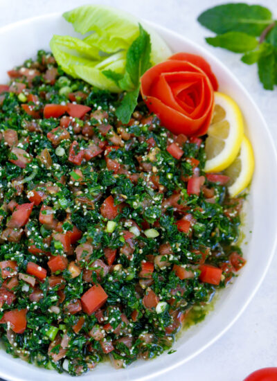 Lebanese tabbouleh garnished with sliced lemons and vegetables