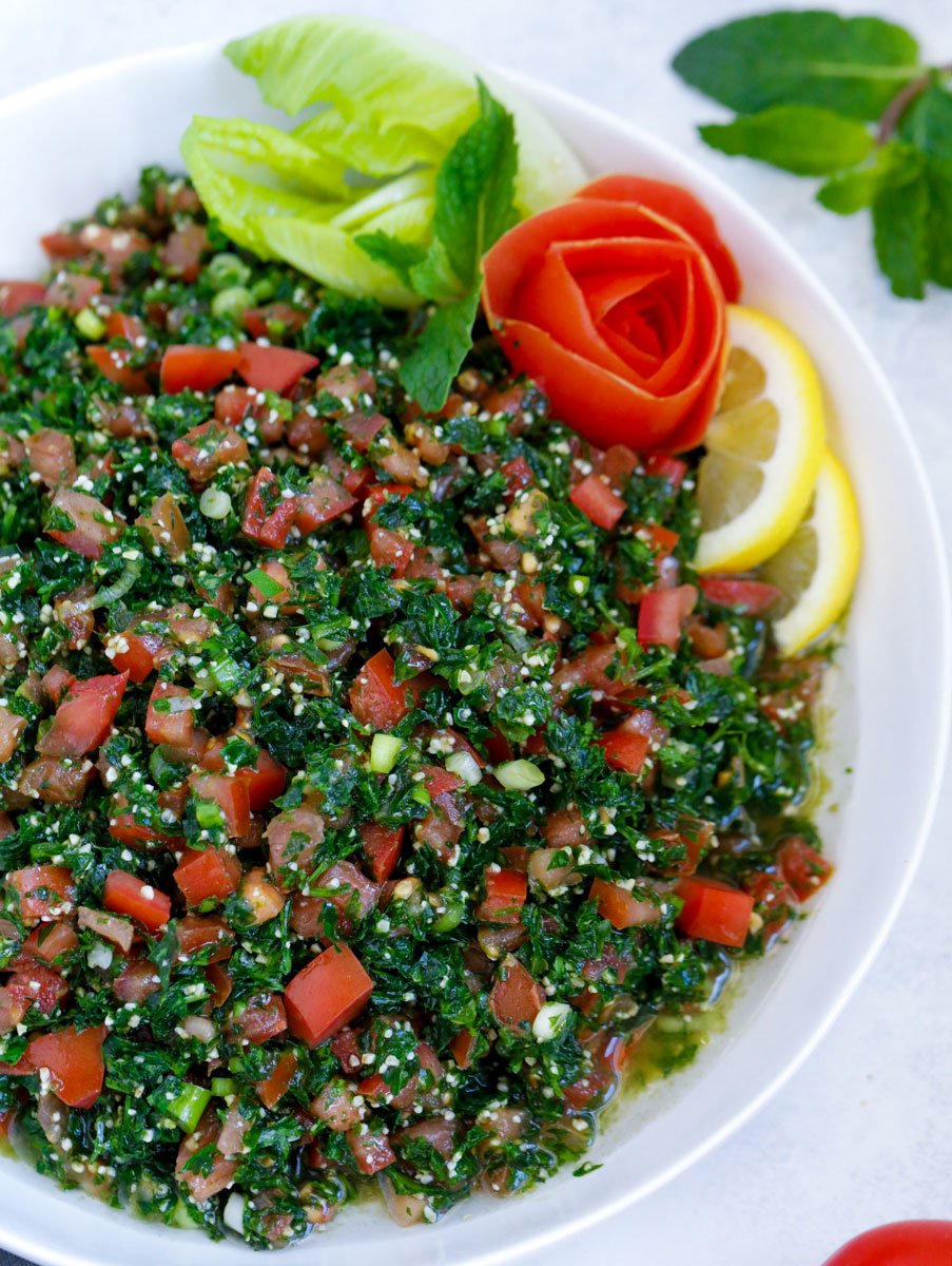 Lebanese tabbouleh garnished with sliced lemons and vegetables