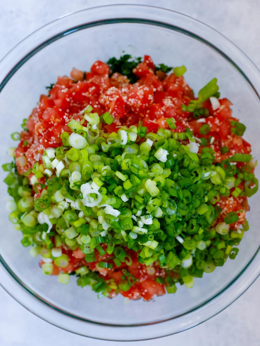 The tabbouleh salad ingredients in a glass bowl