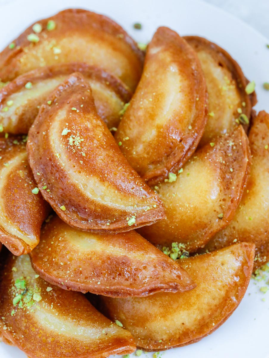 fried atayef garnished with ground pistachios