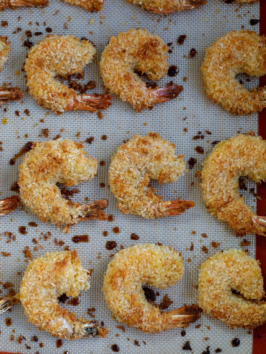 The cooked coconut shrimp on a baking sheet