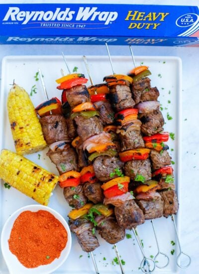 Grilled beef kebobs on a white plate