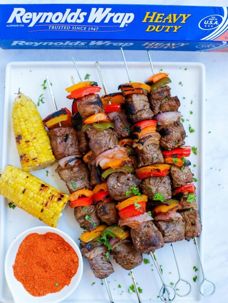 Grilled beef kebobs on a white plate