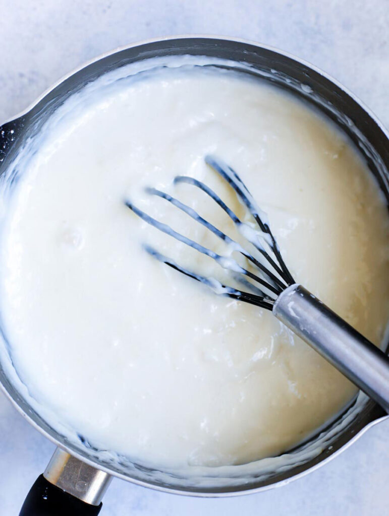 ashta filling in a pot with a whisk