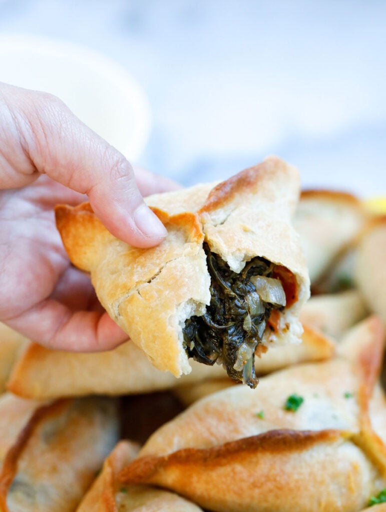 a piece of spinach pie with a bite showing the filling