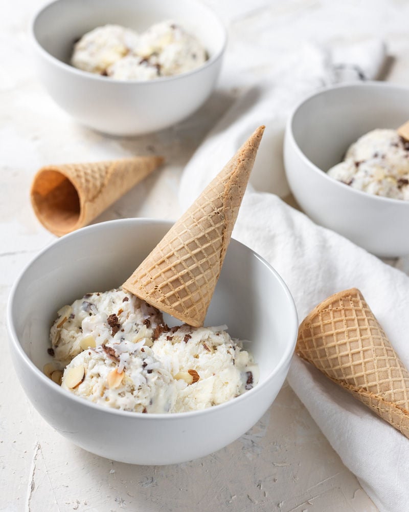 almond joy ice cream in a bowl topped with a cone