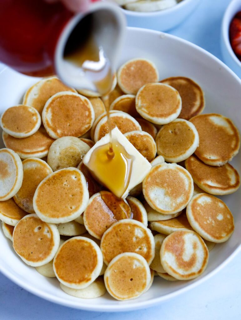 pancake syrup being pour on pancakes