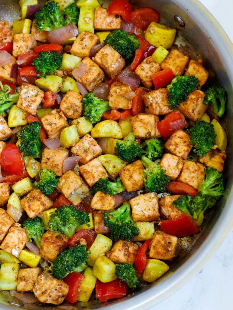 close up of salmon and veggies in a skillet