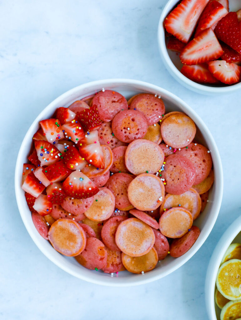 mini strawberry pancakes served with fresh strawberries and sprinkles