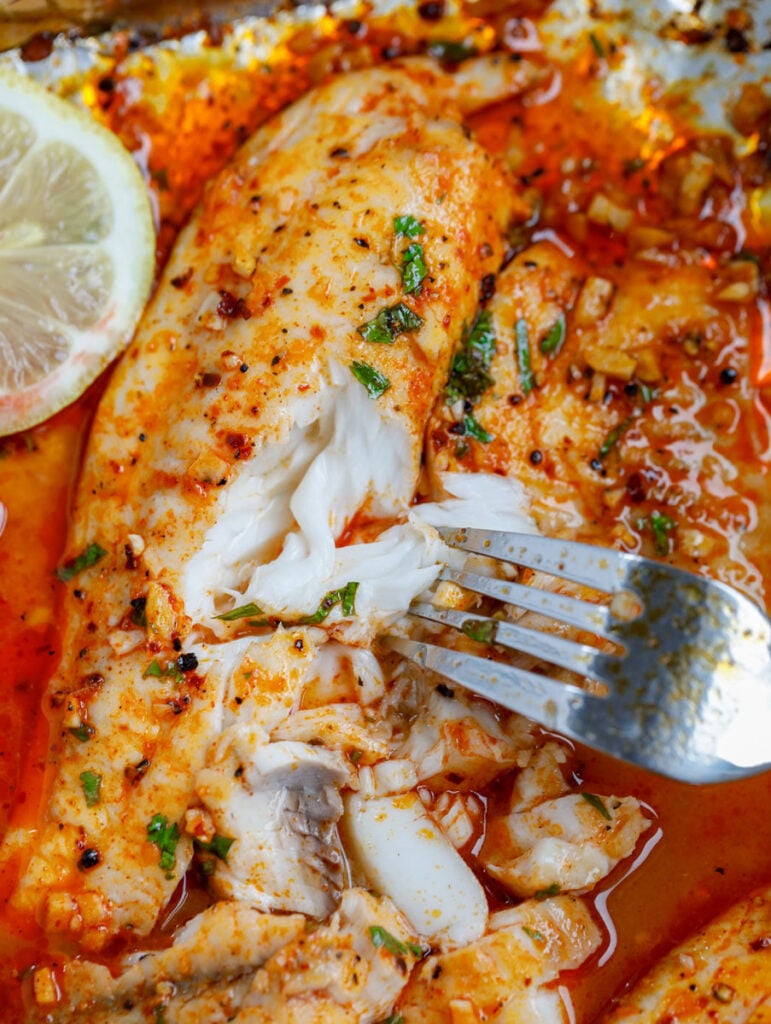 fork going into baked tilapia