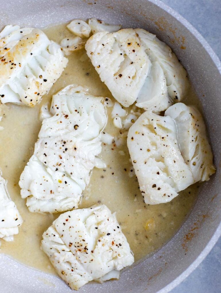 top down shot of cod in a white skillet
