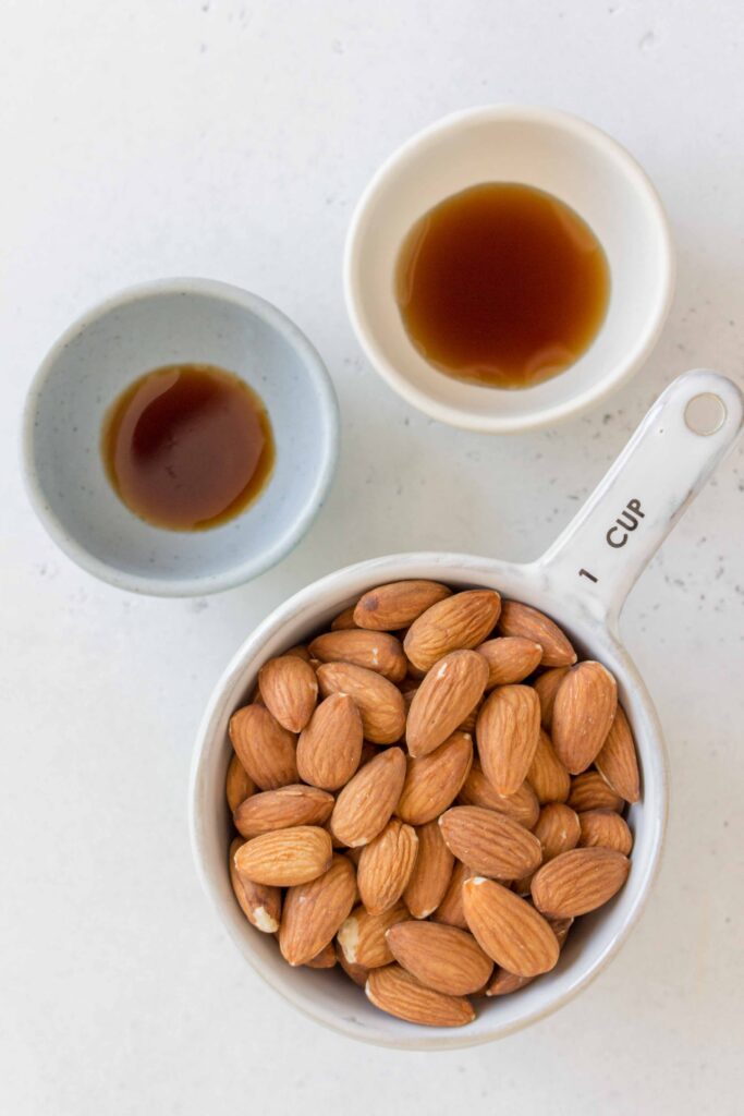 ingredients for almond milk: almonds, maple syrup, and vanilla extract