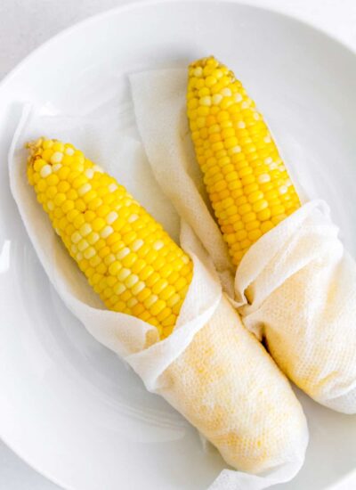 cooked corn on a plate wrapped with paper towel.