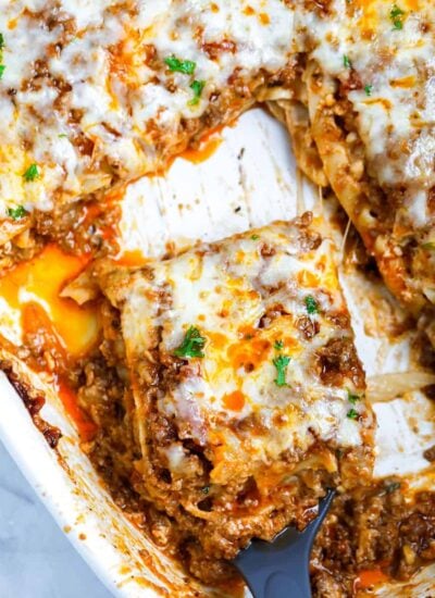 slice of Meat Lasagna being taken from a dish in a spatula.