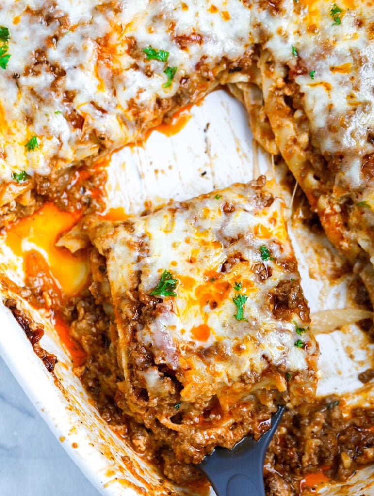 slice of Meat Lasagna being taken from a dish in a spatula.