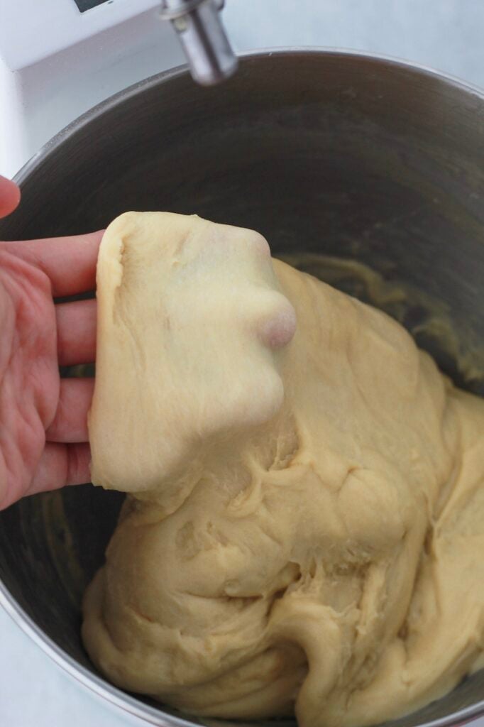 Image of checking if the dinner roll bread dough passes the windowpane test.