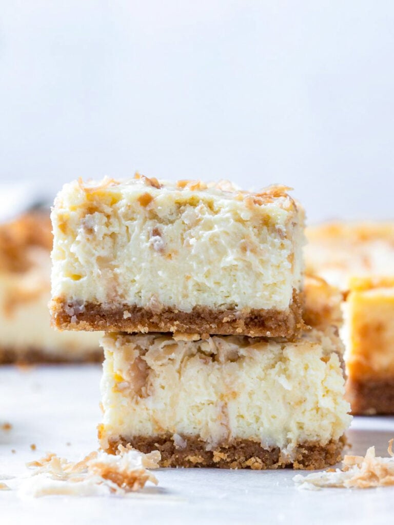 coconut cheesecake bars stacked on top of each other