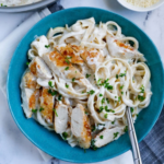 Sliced golden chicken over fettuccine in Parmesan cream sauce with fresh parsley.
