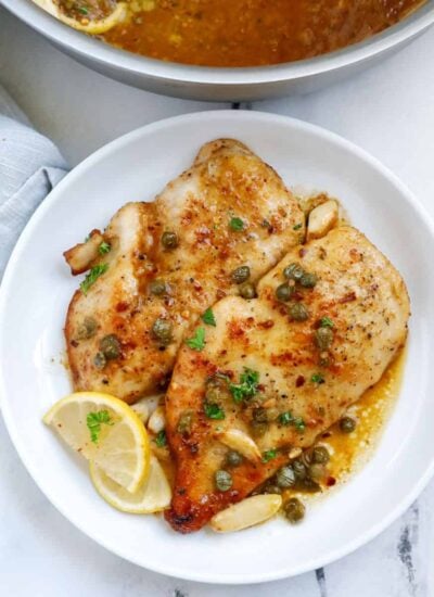 lemon chicken piccata pieces on a white plate