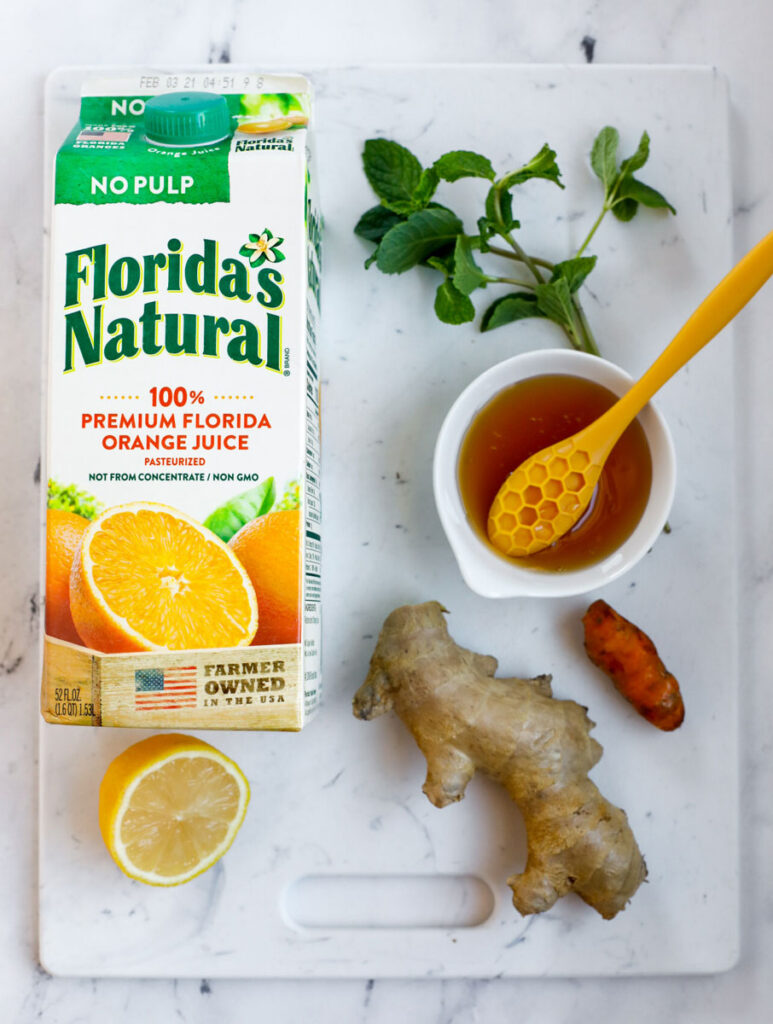 top down shot of the ingredients for the orange juice booster drink