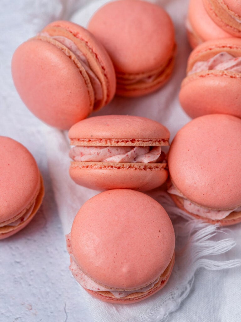 Multiple French macarons that are pink.