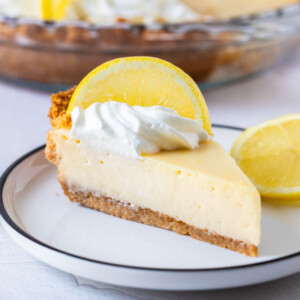 a slice of creamy lemon pie topped with a slice of lemon