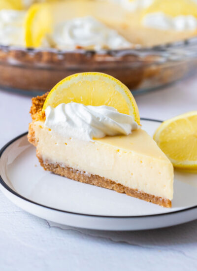 a slice of creamy lemon pie topped with a slice of lemon
