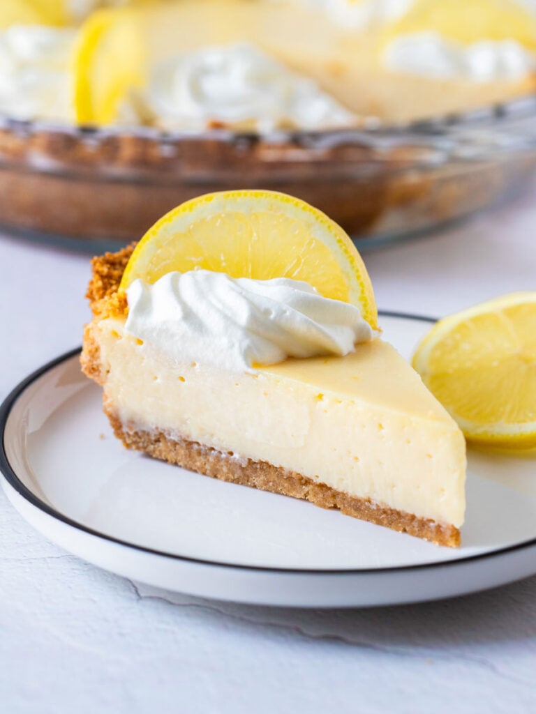 a slice of creamy lemon pie topped with a slice of lemon