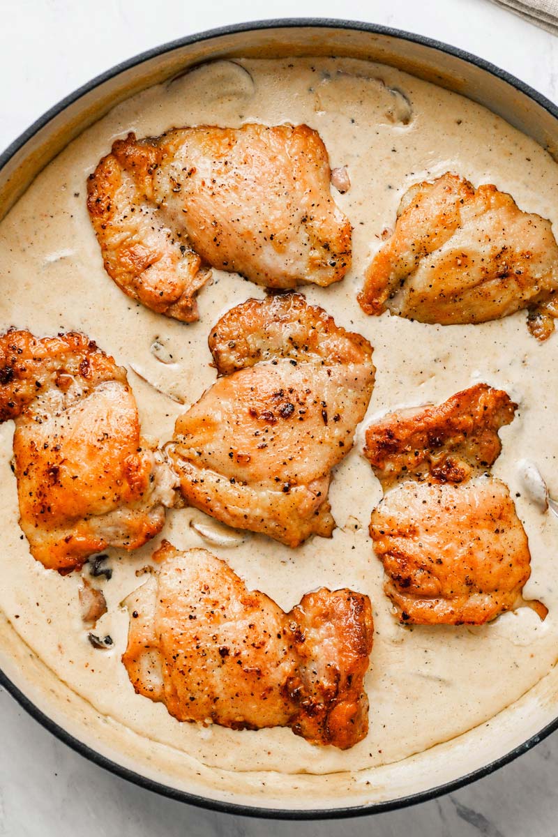 top down shot of chicken thighs after it's returned into the skillet