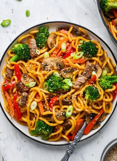beef lo mein served on a plate and garnished with sesame seeds