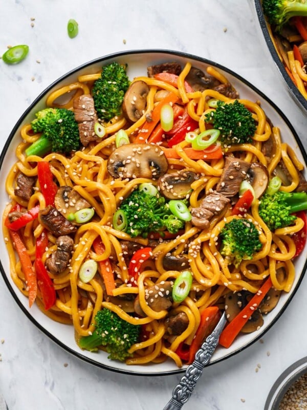 beef lo mein served on a plate and garnished with sesame seeds
