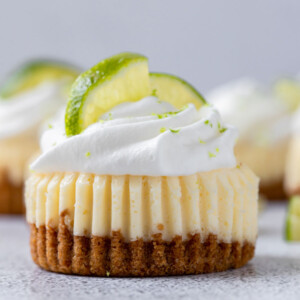 close up shot of mini key lime cupcake with whipped cream and lemon slices on top