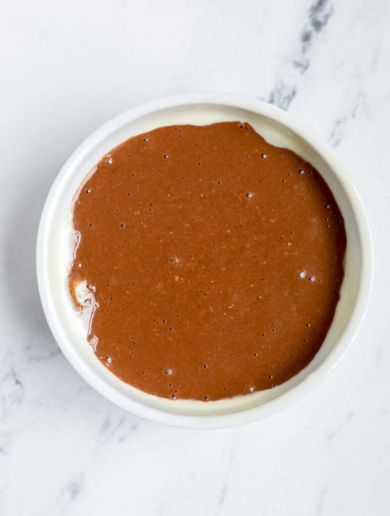 Chocolate peanut butter baked oats batter in a ramekin.